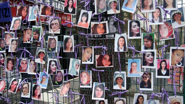 Les photos d'une cinquantaine de femmes sont accrochés à un grillage avec des fils violets Les photos d'une cinquantaine de femmes sont accrochés à un grillage avec des fils violets