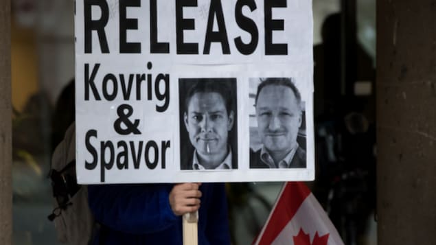 2020年一月，温哥华最高法院外，抗议者高举释放两名麦克的牌子。