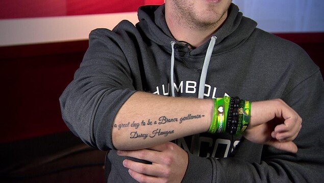 Tyler Smith montre son tatouage sur le bras, citant l'entraîneur défunt Darcy Haugan où l'on peut lire en anglais: « C'est un grand jour pour être Bronco Messieurs », Darcy Haugan. Tyler Smith montre son tatouage sur le bras, citant l'entraîneur défunt Darcy Haugan où l'on peut lire en anglais: « C'est un grand jour pour être Bronco Messieurs », Darcy Haugan.