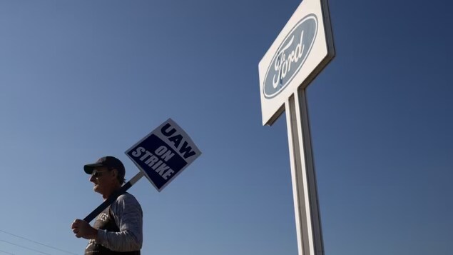 A United Auto Workers member holds a sign outside a Ford assembly plant in Wayne, Mich., on Friday. The site is one of three facilities currently shut down, but that list could expand in a hurry if the union makes good on its threat. (Emily Elconin/Bloomberg)
