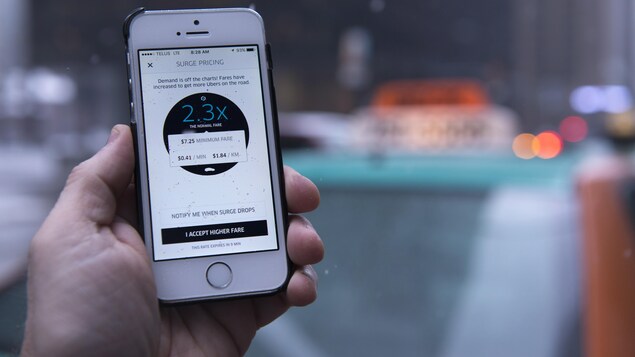Un téléphone mobile ouvert sur une application mobile devant un taxi.