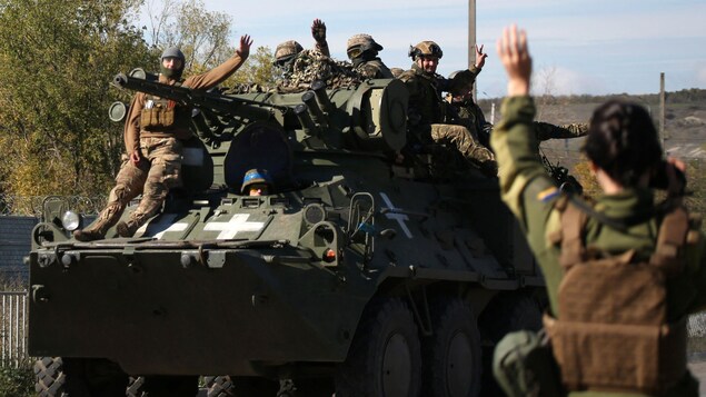 Des soldats ukrainiens sur un véhicule blindé de transport de troupes sur une route de la région de Donetsk.