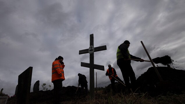  Des hommes creusent des tombes dans le cimetière du village de Hroza, près de Kharkiv, en Ukraine, le 9 octobre 2023. 