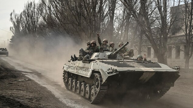 Des soldats ukrainiens circulent en char d'assaut.
