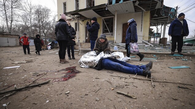 Une vieille femme s'agenouille devant le corps de son fils, tué lors d'une frappe russe en Ukraine.