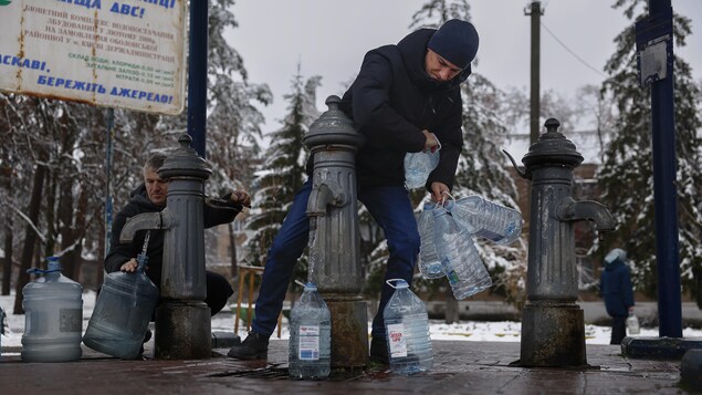 Des Ukrainiens recueillent de l'eau.