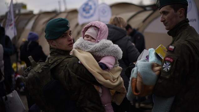 Un soldat polonais tient un bébé.