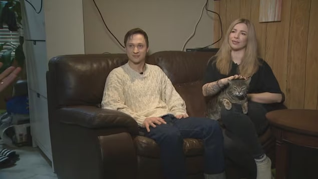 أندري باتيتسكي وزوجته كاترينا بوندارينكو يجلسان على كنبة في منزلهما في منطقة فانكوفر الكبرى.