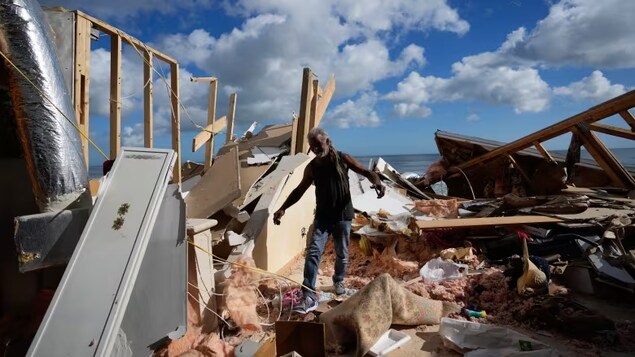 A man walks through the wreckage of the beachfront home that collapsed following beach erosion from Hurricane Nicole on Nov. 12, 2022, in Wilbur-By-The-Sea, Fla. A new UN report has some key points to make before the world hits 1.5 C of warming, a threshold where scientists say 'risks start to pile up.' (Rebecca Blackwell/The Associated Press)