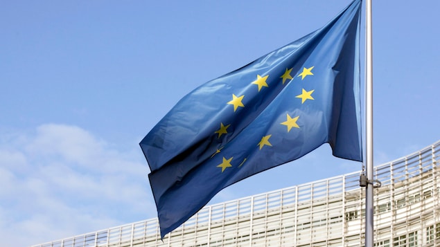 Le drapeau de l'UE flottant devant les locaux de l'Union européenne.