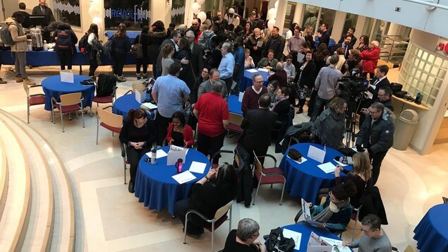 Des gens qui se parlent autour de tables dans une salle. Des gens qui se parlent autour de tables dans une salle.