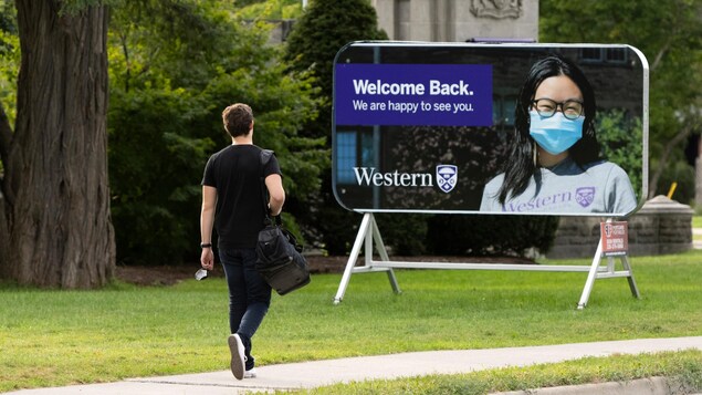 Une affiche sur le campus de l'Université Western où l'on voit une étudiante portant un masque.