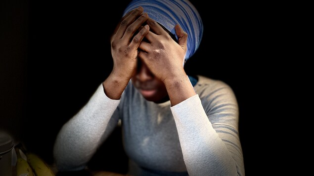 Une femme prend sa tête entre ses mains.