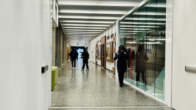 Des étudiants marchent dans un corridor.