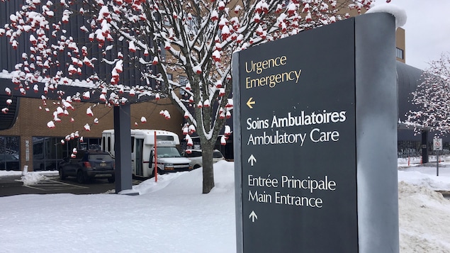 Une affiche dirigeant les gens vers l'urgence d'un hôpital entourée de neige.