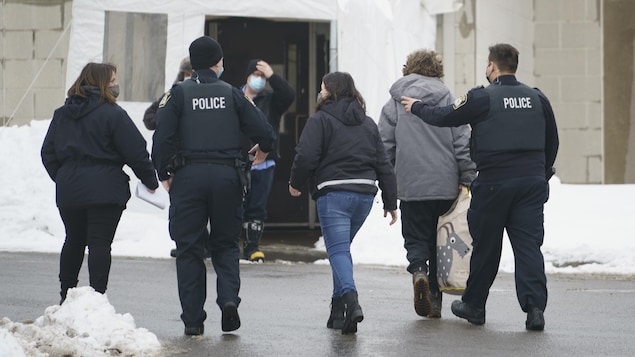 Policiers et intervenants marchent dans la rue.