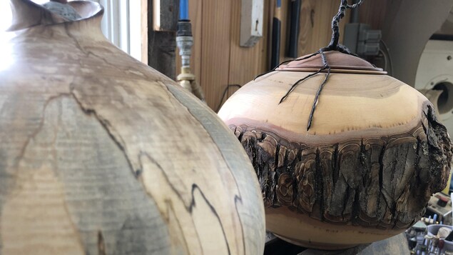 Deux urnes en bois. Sur l'une, il y a encore de l'écorce.