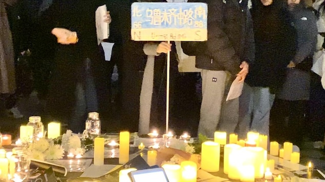 蒙特利爾聲援活動中，有人手持“烏魯木齊中路”的牌子，那里正是上海抗議中心地點。