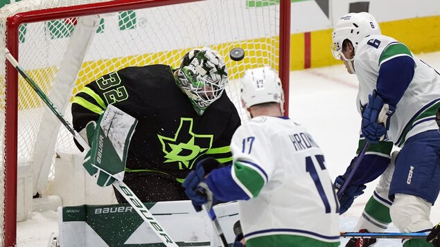 Le gardien de but des Stars, Matt Murray, tente de se défendre contre les attaquants Filip Hronek et Brock Boeser, des Canucks de Vancouver, lors d'un match à Dallas, le samedi 25 mars 2023.