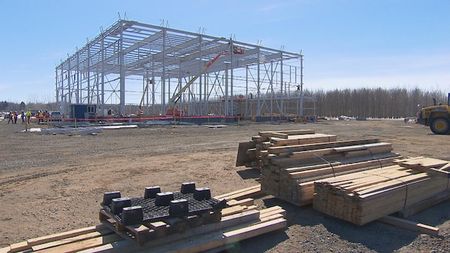 Un immeuble en pleine construction avec des planches de bois en hiver.