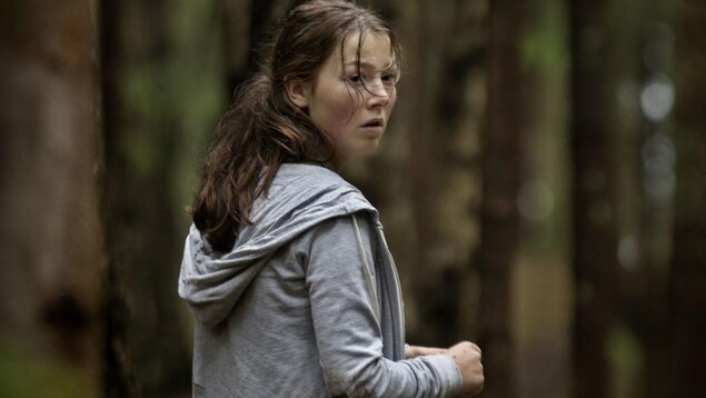 Une jeune fille semble en danger dans une forêt, dans une scène du film norvégien Utøya 22. juli . Une jeune fille semble en danger dans une forêt, dans une scène du film norvégien Utøya 22. juli .