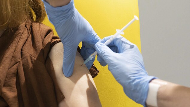 Le bras d'une femme dans lequel on fait une injection lors d'essais d'un vaccin contre la COVID-19.