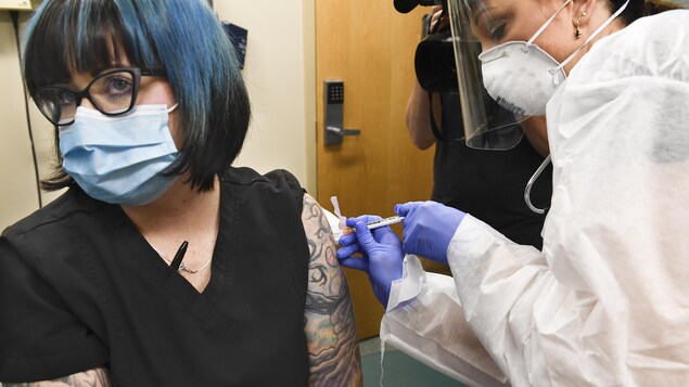 Une femme reçoit une injection d'une infirmière dans le cadre d'une étude clinique.
