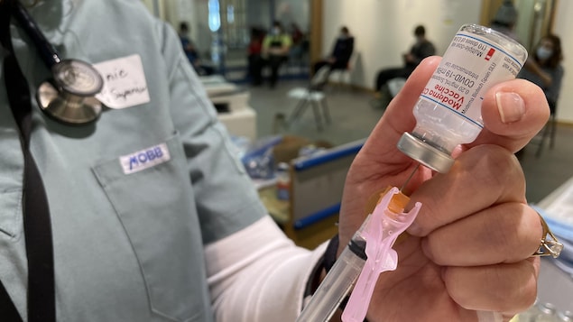 Une aiguille perce une fiole du vaccin de Moderna.