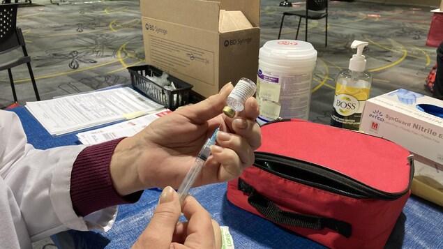 Une femme se prépare à administrer un vaccin.