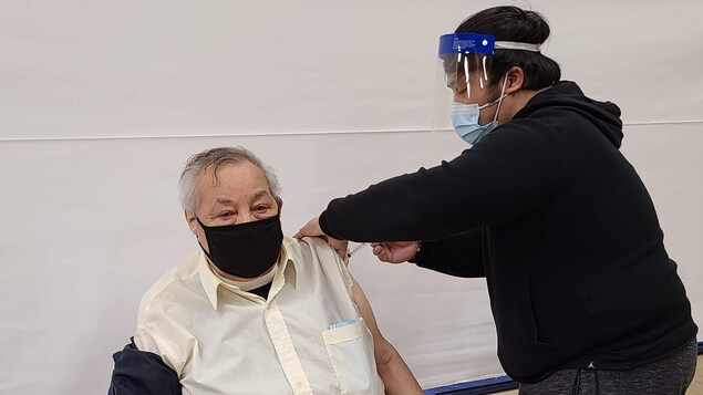 Un homme se fait vacciner.