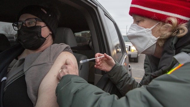 Un homme se fait vacciner dans sa voiture à Kingston, le 18 décembre.