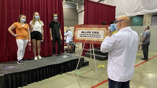 Des jeunes se font prendre en photo au centre de vaccination d'ExpoCité.