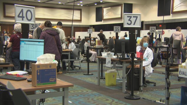 Des gens attentent pour se faire vacciner à l'Intérieur du Palais des congrès de Gatineau.
