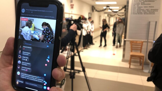 Quelqu'un assiste à la vaccination sur son cellulaire.