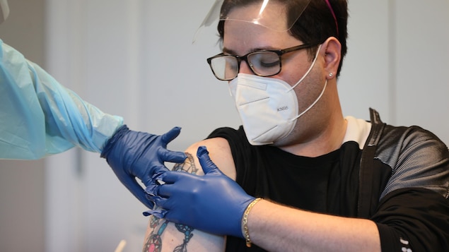 Un homme appuie sur son bras après avoir été vaccin