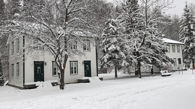 Des maisonnettes enneigées sur le site de Val-Jalbert.