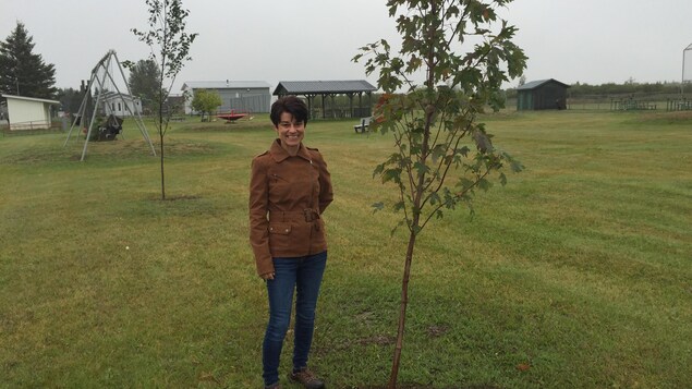 La mairesse de Val Rita-Harty, Johanne Baril, pose à côté d'un érable planté au parc de Val Rita.