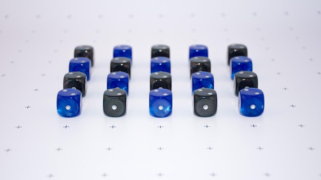 Des dés à jouer noirs et bleus alignés de façon régulière sur un fond blanc à petites croix noires. Des dés à jouer noirs et bleus alignés de façon régulière sur un fond blanc à petites croix noires.