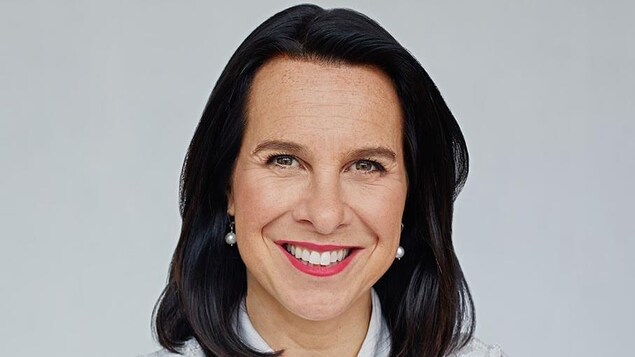 Valérie Plante, qui porte du rouge à lèvres, sourit.