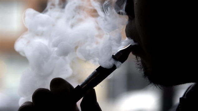 Un homme utilise une cigarette électronique.