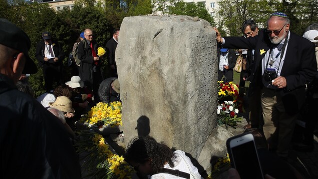 Jonquilles épinglées aux vêtements, des gens ont déposé des fleurs sur un monument érigé sur un monticule, à Varsovie, qui est à la fois une fosse commune et l'endroit où se trouvait le bunker de commandement des partisans juifs qui ont combattu dans le ghetto de Varsovie. Jonquilles épinglées aux vêtements, des gens ont déposé des fleurs sur un monument érigé sur un monticule, à Varsovie, qui est à la fois une fosse commune et l'endroit où se trouvait le bunker de commandement des partisans juifs qui ont combattu dans le ghetto de Varsovie.