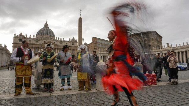 Des membres de la délégation autochtone performent une danse traditionnelle sur la Place St-Pierre, au Vatican, le 31 mars 2022.