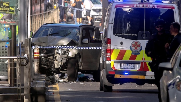 Des policiers australiens se tiennent près d’un véhicule accidenté après avoir arrêté le conducteur qui aurait foncé délibérément sur des piétons à une intersection de Melbourne, le 21 décembre 2017. Des policiers australiens se tiennent près d’un véhicule accidenté après avoir arrêté le conducteur qui aurait foncé délibérément sur des piétons à une intersection de Melbourne, le 21 décembre 2017.