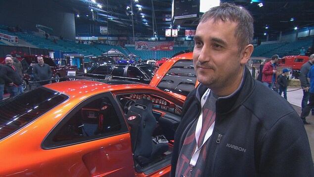 Un homme devant une voiture modifiée Un homme devant une voiture modifiée