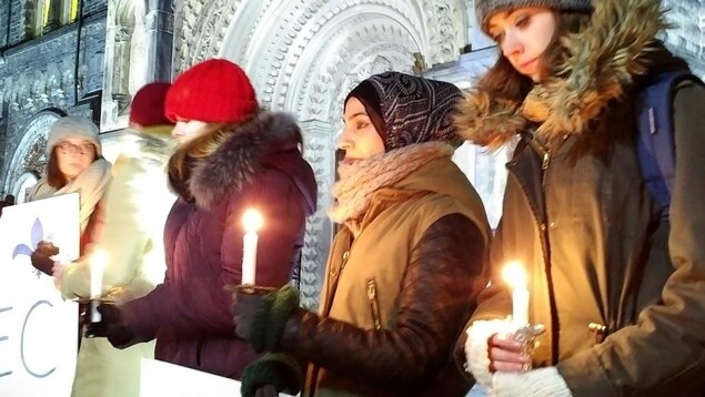 De jeunes femmes tenant des chandelles se recueillent