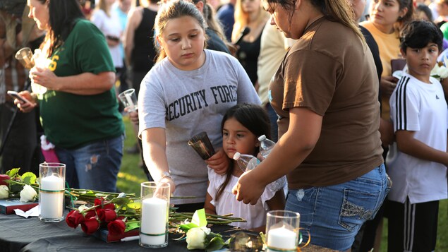 Des jeunes femmes déposent des fleurs à la mémoire des victimes de la fusillade survenue vendredi dans une école secondaire de Sante Fe. Des jeunes femmes déposent des fleurs à la mémoire des victimes de la fusillade survenue vendredi dans une école secondaire de Sante Fe.