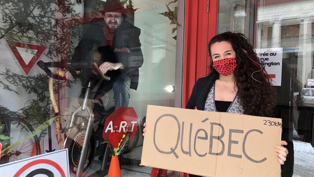L'artiste Arianne Deslions tient une affiche indiquant «Québec».