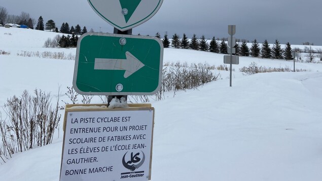 Des affiches sur une piste cyclable l'hiver.