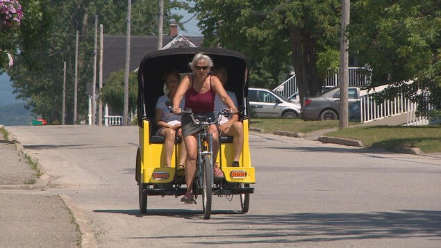 On voit le vélo en action avec deux personnes à bord On voit le vélo en action avec deux personnes à bord