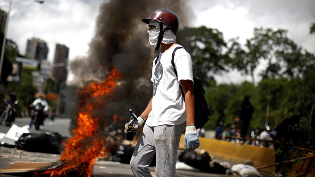 Un manifestant devant des objets qui brûlent. Un manifestant devant des objets qui brûlent.